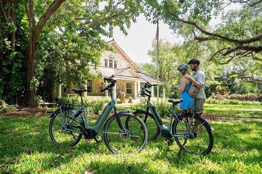 A house with a garden, two bicycles, and a couple standing by the house. 3