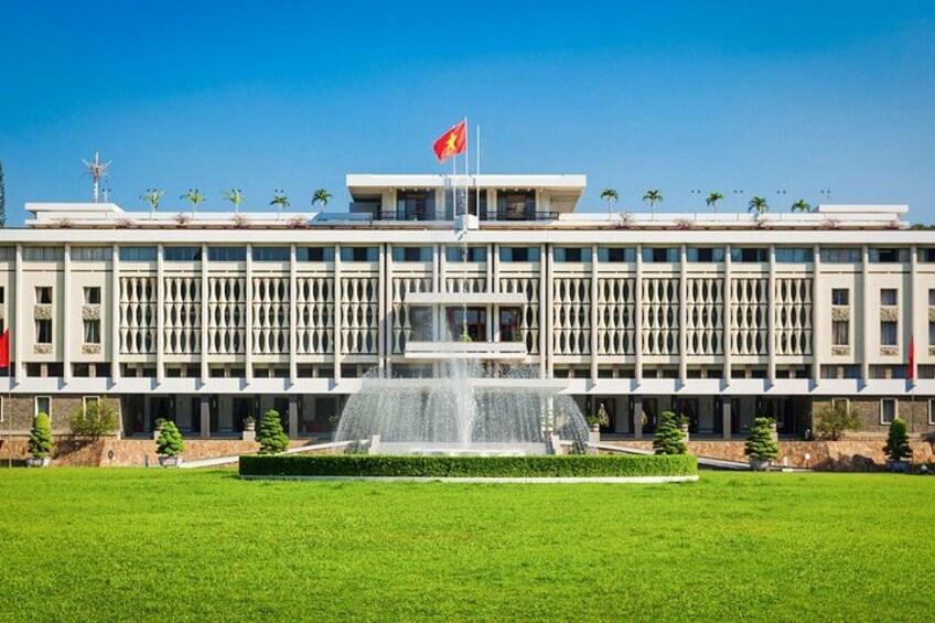 A large building with a flag, a fountain, and a well-maintained lawn. 3