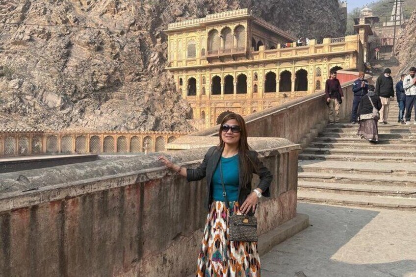 A person standing on a stone bridge with a historic building in the background. 5