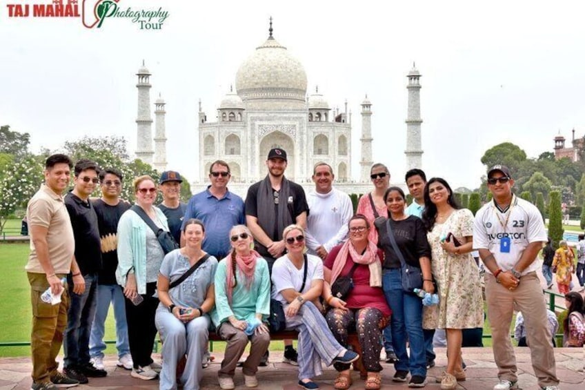 A group of people posing in front of the Taj Mahal. 4