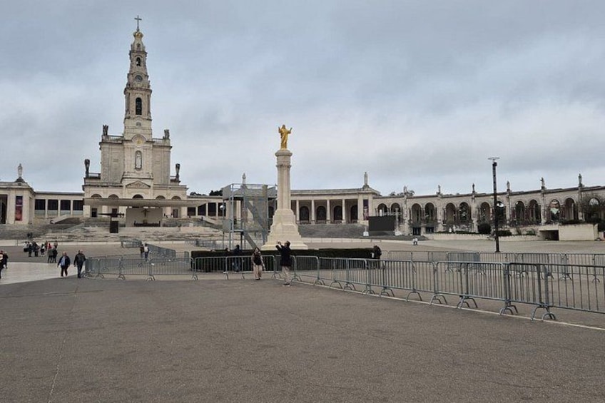 A plaza with a large church, a statue, and a fountain. 2