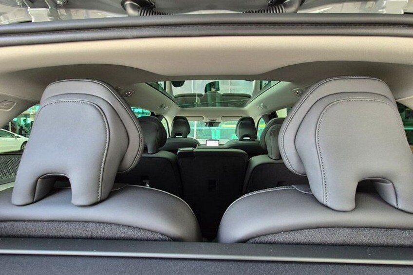 The interior of a car with grey leather seats and a sunroof. 2