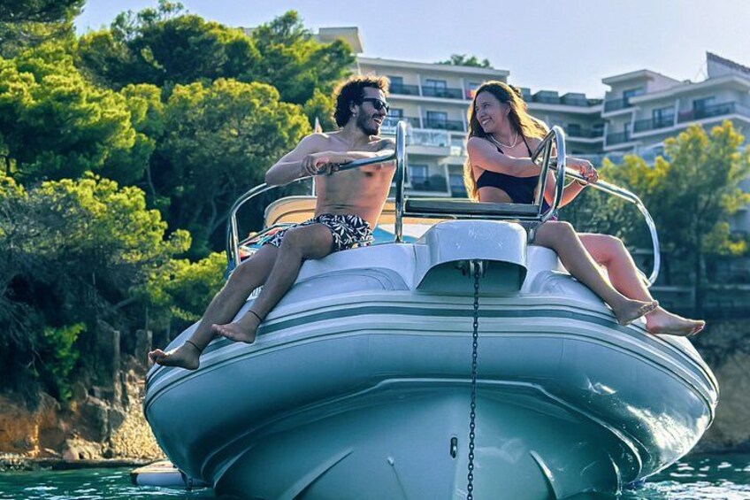 Two people on a motorboat with a cityscape in the background. 2