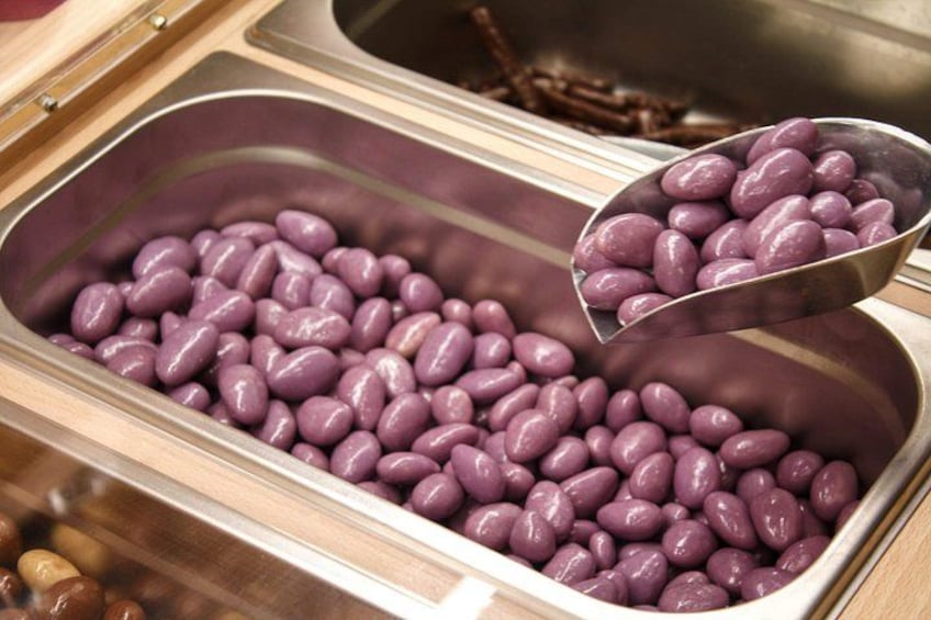 Un contenitore pieno di fagioli viola, con un mestolo di fagioli tenuto sopra. 4