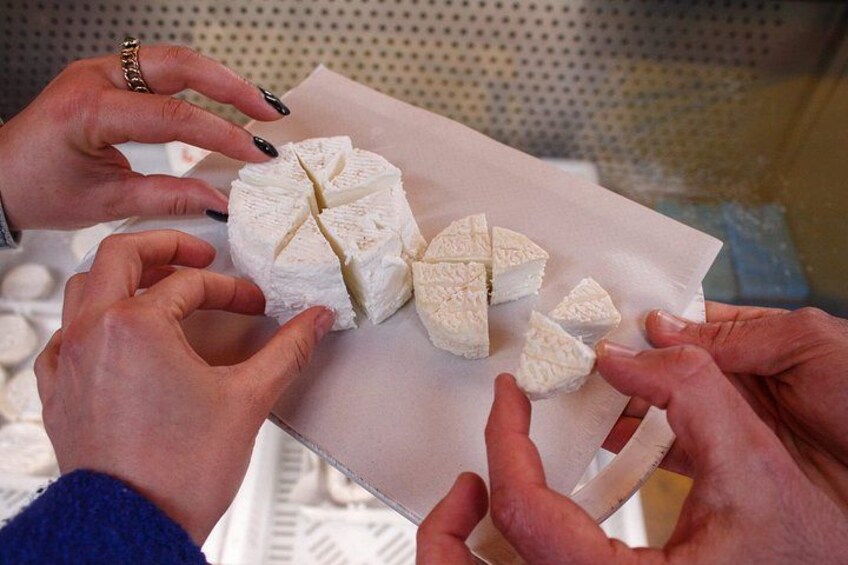 Mani che maneggiano un formaggio bianco con motivo a croce, su un tovagliolo di carta. 1