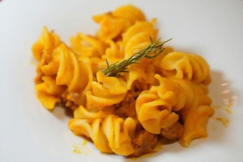 A plate of pasta with a garnish. 5