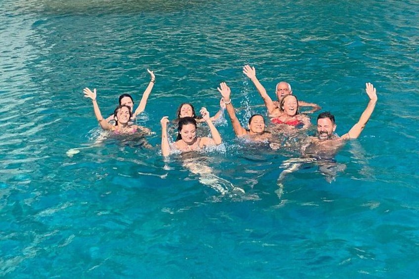 A group of people swimming in a clear blue pool. 2