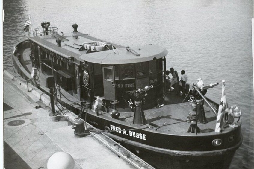 Un barco llamado 'Fire A. Busse' atracado en un muelle, con gente embarcando y desembarcando. 4