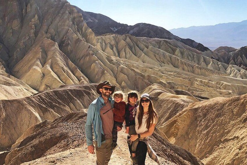 A group of people standing on a ridge with a desert landscape in the background. 2
