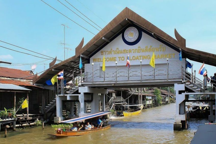 A floating market with boats and a building with a sign that reads 'Welcome to Floating Market'. 2