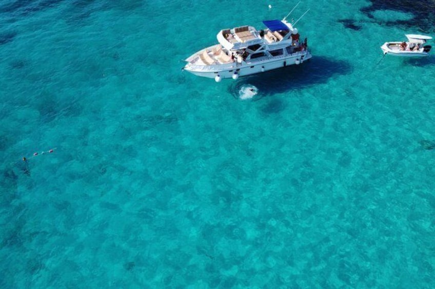 Una barca con passeggeri su un mare turchese cristallino. 5