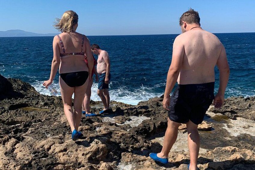 Des personnes se promènent sur un terrain rocheux près de l’océan. 4
