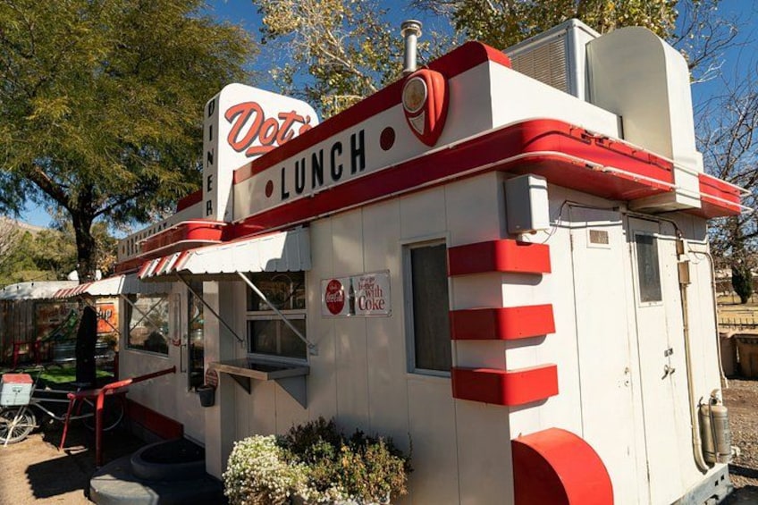 Un clásico restaurante con decoración roja y blanca, un letrero que dice 'Diner Lunch' y un anuncio de Coca-Cola. 5