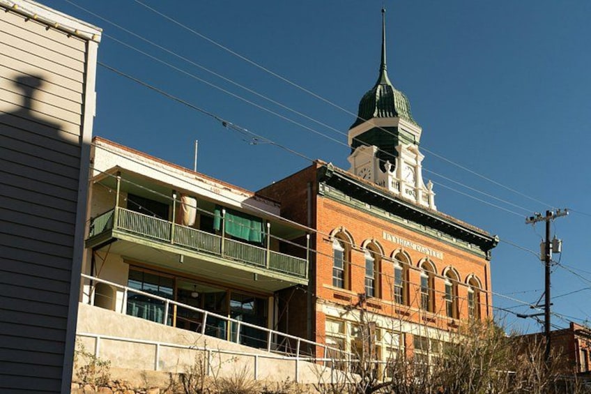 Un edificio histórico con una aguja verde, un balcón y una torre del reloj. 2