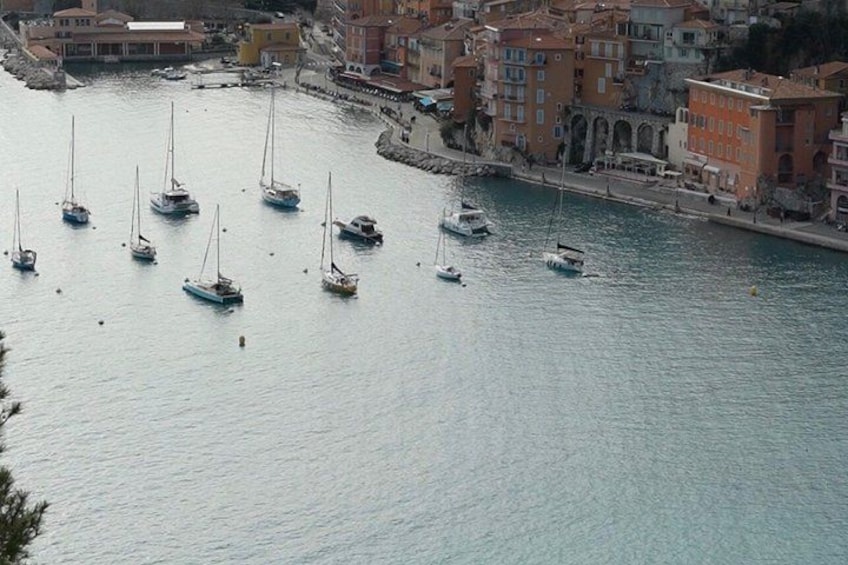 Un porto con barche a vela ormeggiate lungo la banchina, circondato da edifici colorati. 3