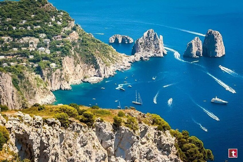 A coastal landscape with rocky cliffs, a village, and boats in the water. 1