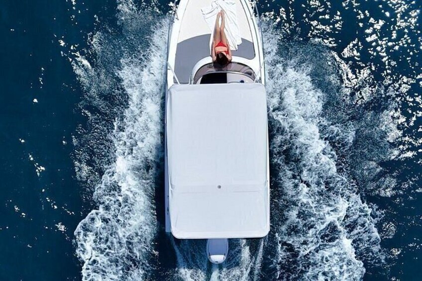En hvid båd sejler gennem vandet og efterlader et spor bag sig. 3