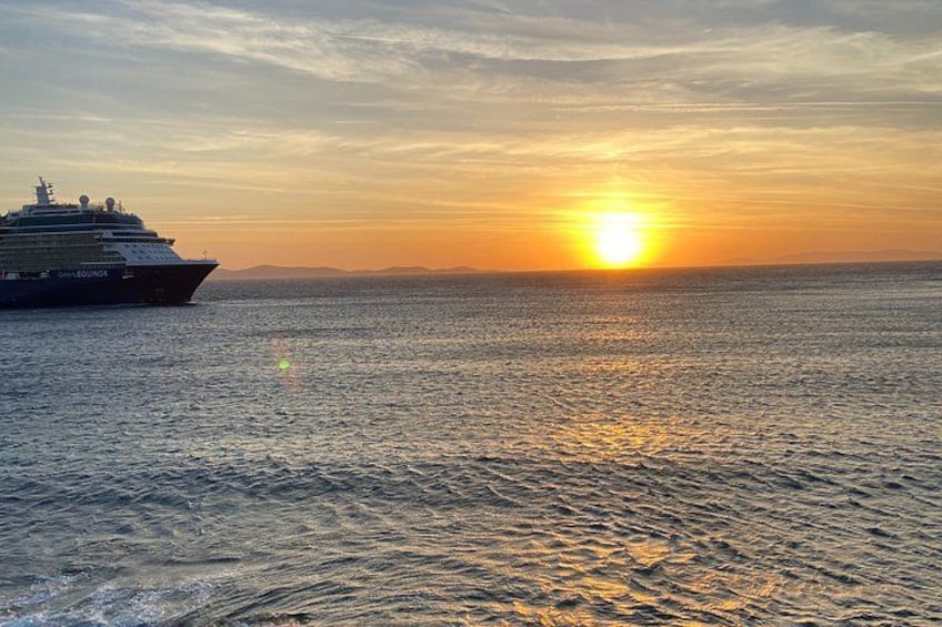 A cruise ship at sunset with the sun reflecting on the water. 4