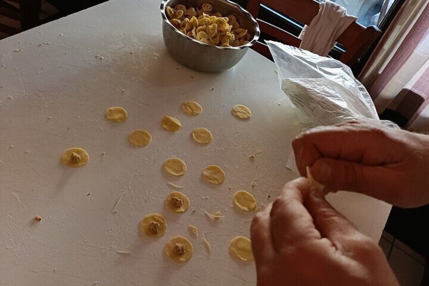 Handen bereiden eten, met een kom ingrediënten en een plastic zak op een tafel. 5