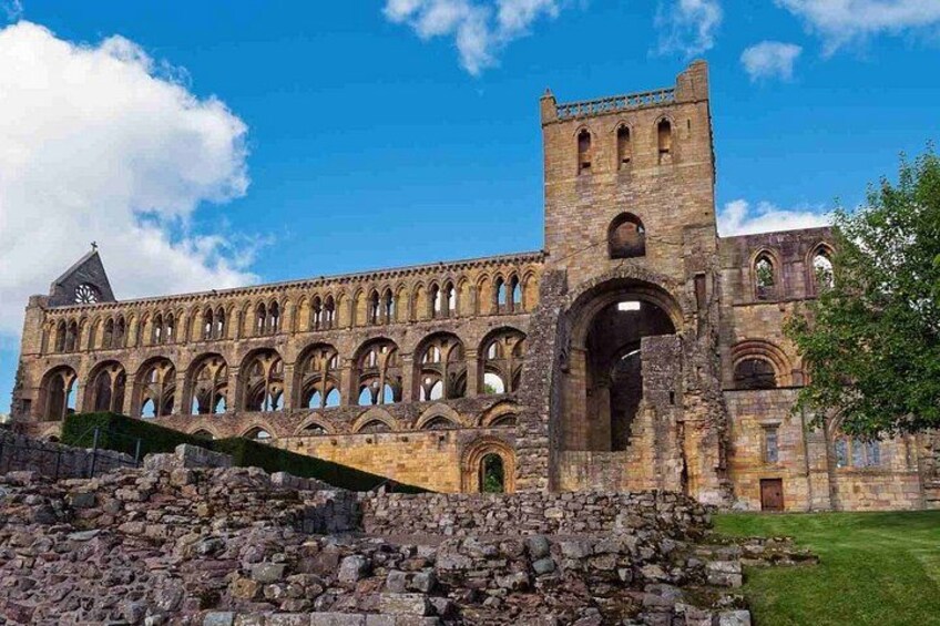 Un bâtiment historique en pierre, doté de fenêtres en arc de cercle et d’une tour. 3