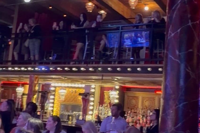Un bar con escenario, luces y mucha gente. 5