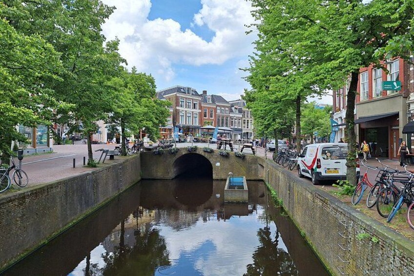A canal with a bridge, trees, and buildings along the banks. 5