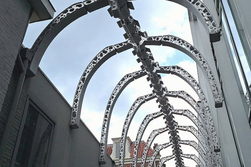 A metal sculpture with interlocking arches and a chain structure. 3