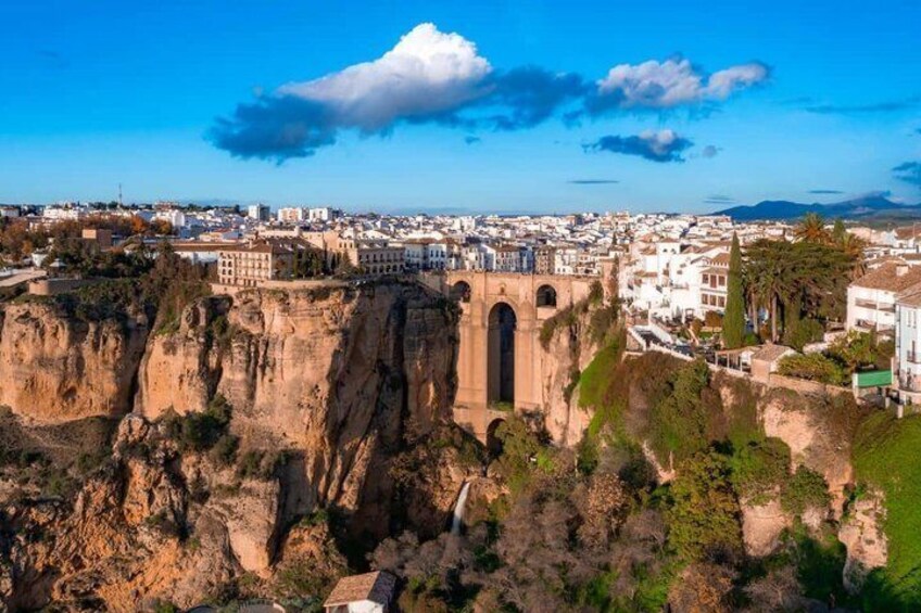 A cityscape with a prominent cliff and a bridge. 1