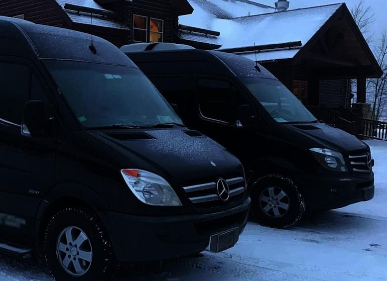 Two black Mercedes vans parked on a snow-covered driveway. 1