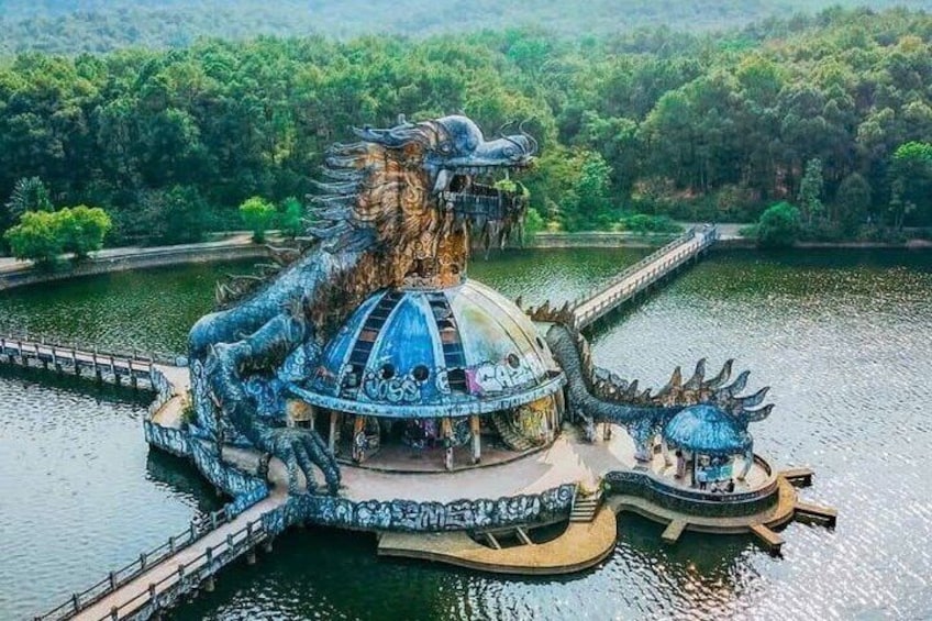 Una estatua enorme de un dragón con un templo en un lago rodeado de follaje. 3