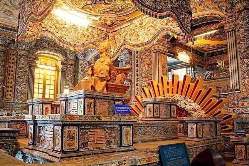 Un interior ornamentado con tallas intrincadas, una estatua central y una estructura parecida al sol. 4