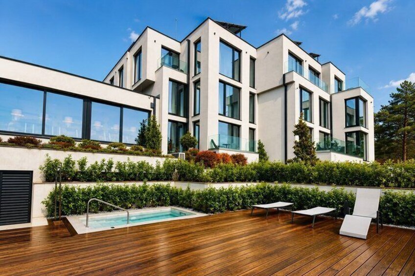 A modern building with a swimming pool and wooden deck. 3