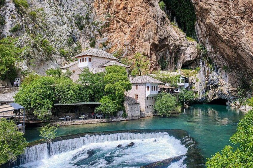A waterfall, a river, and buildings nestled in a rocky gorge. 2