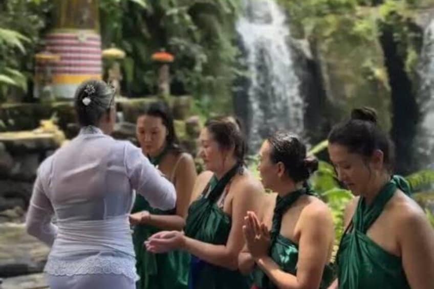 Un grupo de personas en un entorno natural con una cascada al fondo. 2