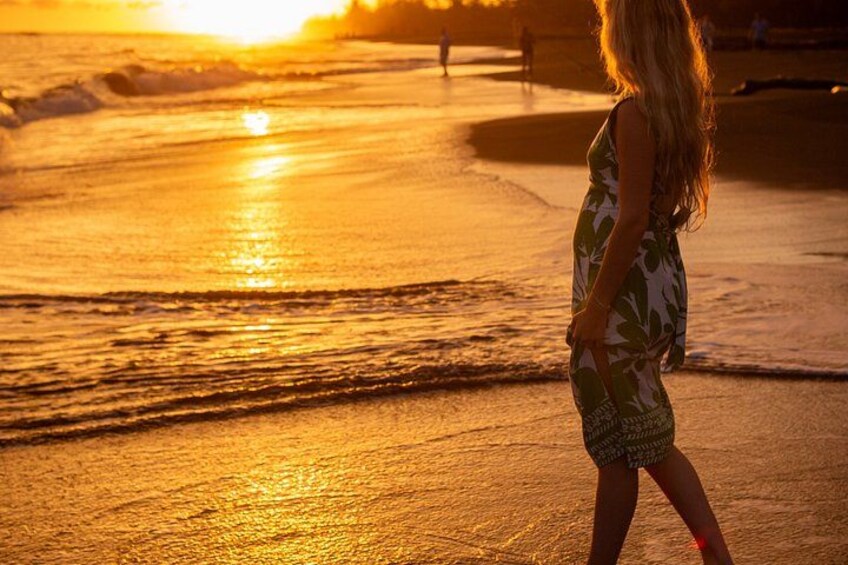Una spiaggia al tramonto con onde, una persona con un abito fantasia e una panchina sullo sfondo. 3