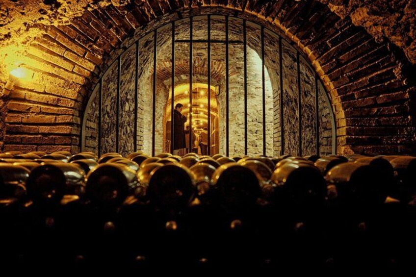 A wine cellar with barrels and a person standing in the background. 4