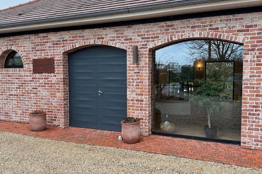 A brick building with a dark blue door and arched windows. 3
