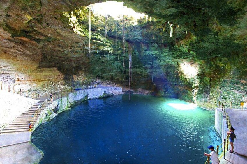 A natural pool with a staircase leading down to the water, surrounded by rocky cliffs. 2