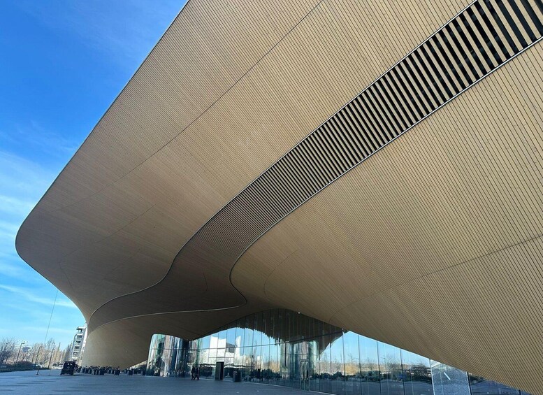 A modern architectural structure with a curved roof and reflective glass facade. 3