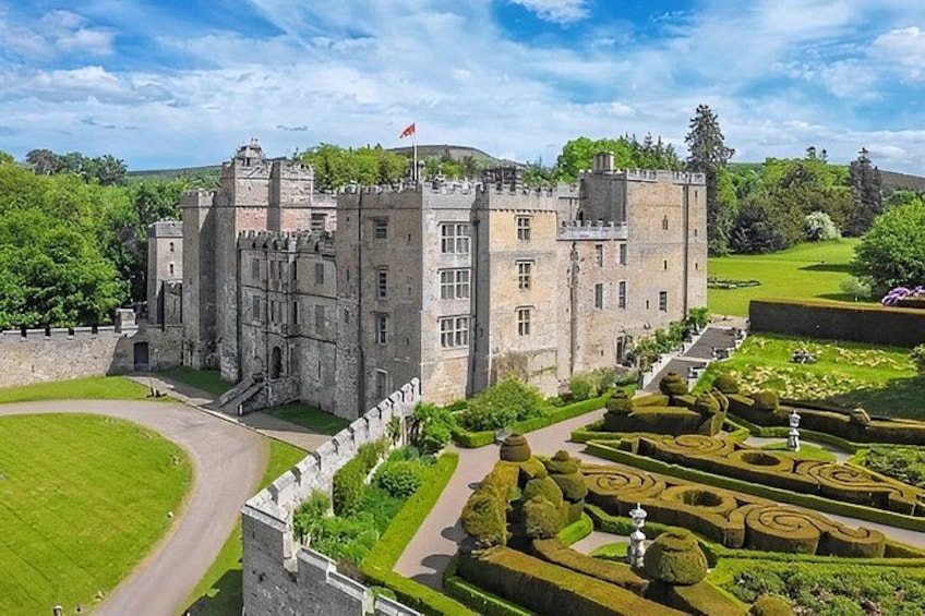 Un castillo con un jardín cuidado y un cielo despejado. 4