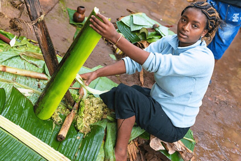 A person sitting on a mat, peeling a banana. 4