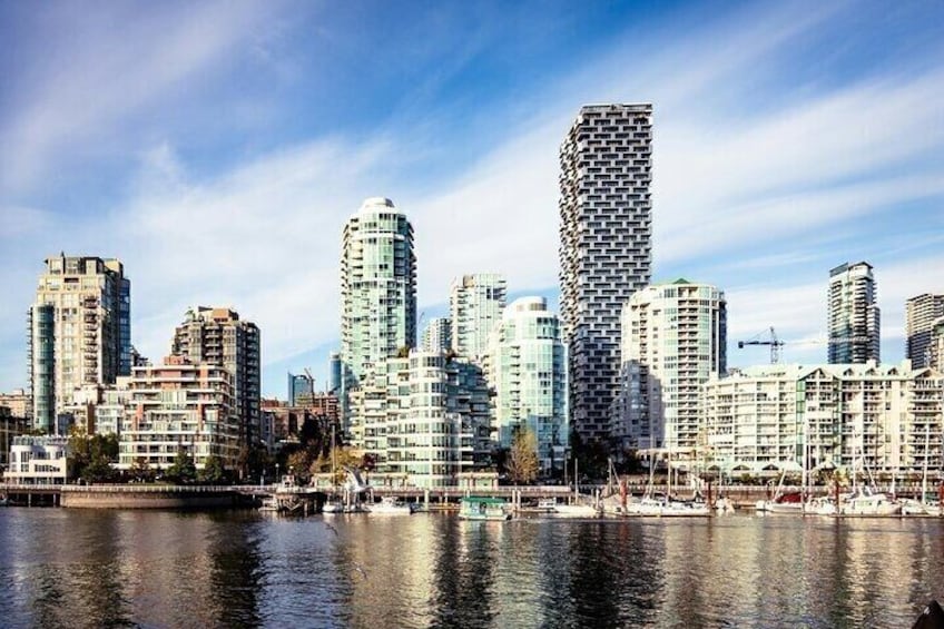 A waterfront cityscape with modern high-rise buildings and a marina. 1