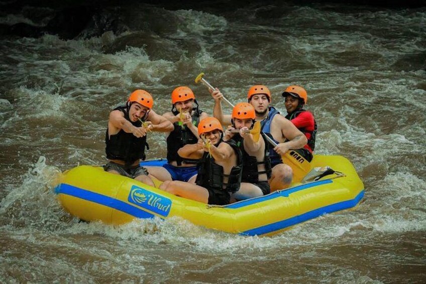 A group of people in a yellow inflatable raft on a river. 5