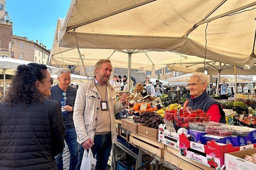 Een markt vol mensen die winkelen en verkopers die fruit en groenten verkopen. 3