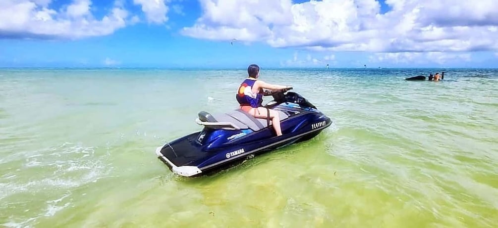 A person riding a Yamaha jet ski on clear turquoise water. 5