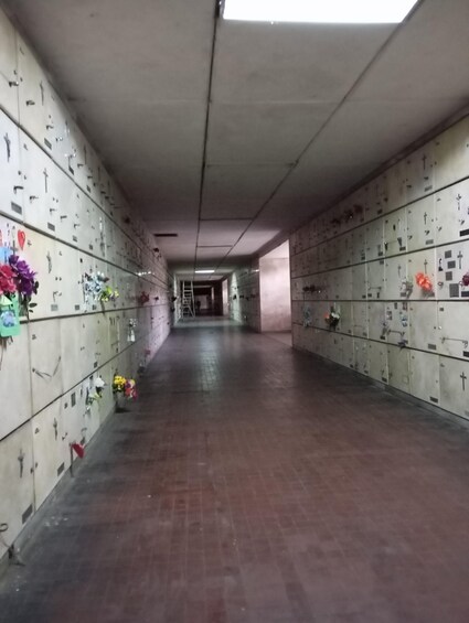 A long corridor with lockers on both sides, some with flowers and personal items. 2
