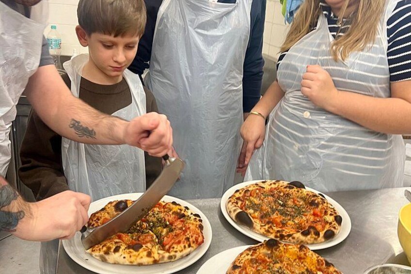 Iemand snijdt een pizza met een mes. 3