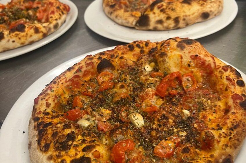 Pizza met toppings en kaas op een bord. 5