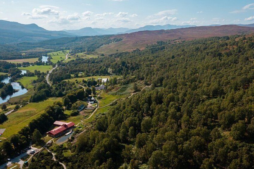 A river winding through a valley with a small settlement and a red-roofed building. 5
