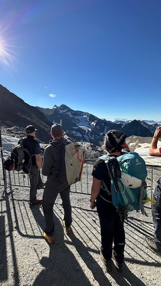 Hikers on a mountain trail with a view of snow-capped peaks. 1